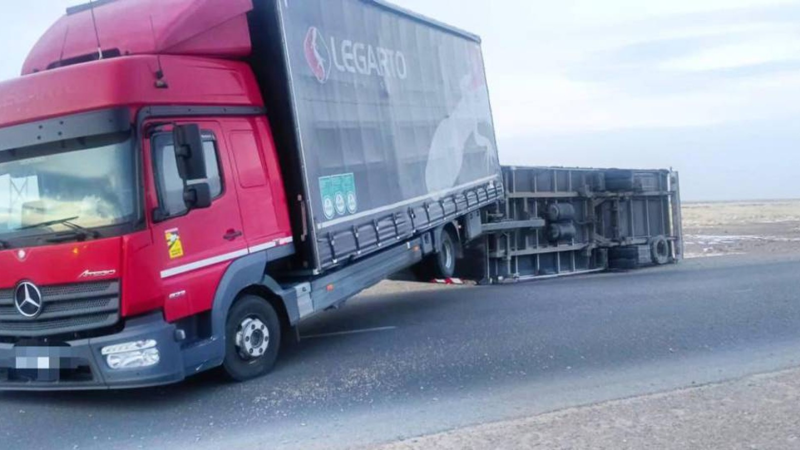 Абай облысында қатты жел жүк көлігінің тіркемесін аударып жіберді.