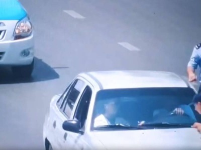 Шымкентте полицей жүріп бара жатқан көлікке секіріп мінген (ВИДЕО).